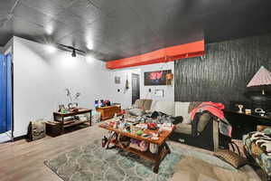 Living area with wood finished floors and rail lighting