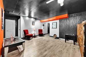 Living area featuring wood finished floors, baseboards, and ceiling fan