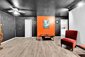 Sitting room featuring wood finished floors, a ceiling fan, and baseboards