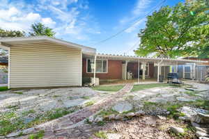 Rear view of property with brick siding and a patio area