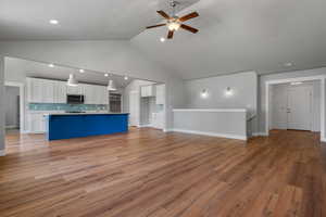 Unfurnished living room featuring ceiling fan, light wood-style flooring, recessed lighting, baseboards, and a sink