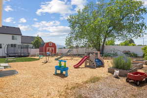 View of play area featuring a trampoline, a fenced backyard, and a vegetable garden