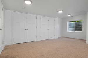 Unfurnished bedroom featuring two closets, carpet flooring, and baseboards