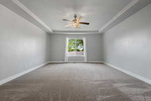 Master bedroom with a ceiling fan, baseboards, and a tray ceiling