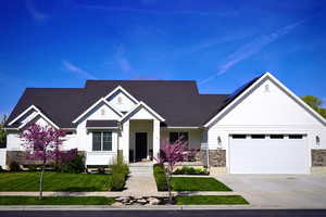 View of front of house featuring stone siding, board and batten siding, a garage, roof with shingles, and driveway