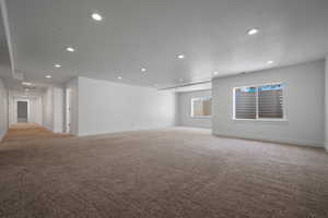 Great/Rec room with light colored carpet, recessed lighting, baseboards, and a textured ceiling