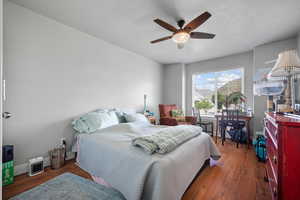 Bedroom featuring wood finished floors, a ceiling fan, and baseboards