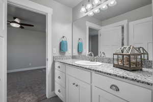 Jack and Jill Bathroom with vanity, a ceiling fan, and baseboards