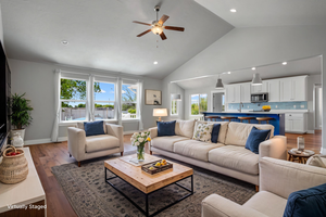 Living area with a ceiling fan, wood finished floors, high vaulted ceiling, recessed lighting, and baseboards