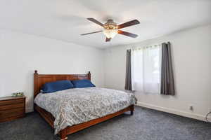 Carpeted bedroom featuring a ceiling fan and baseboards