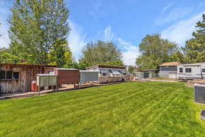 View of yard with central AC unit and exterior structure