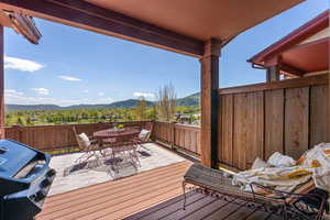 Deck featuring a mountain view, outdoor dining space, and area for grilling