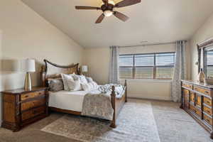 Bedroom with light carpet, lofted ceiling, baseboards, and ceiling fan