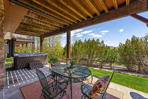 Fenced backyard with a hot tub, outdoor dining space, and a patio