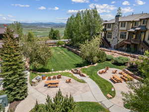 Surrounding community with stairs, a fire pit, a lawn, a patio area, and a mountain view