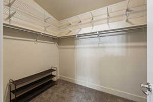Walk in closet featuring dark carpet