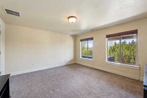 Carpeted empty room featuring baseboards