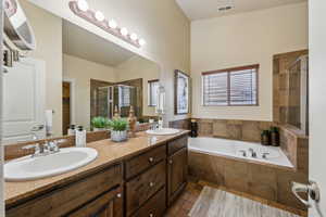 Bathroom with a stall shower, double vanity, tile patterned flooring, a garden tub, and plenty of natural light