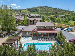Back of property featuring a chimney, a fenced backyard, a mountain view, a community pool, and a patio area