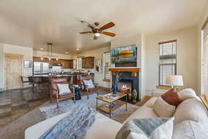 Living room with a ceiling fan, baseboards, a fireplace, and recessed lighting