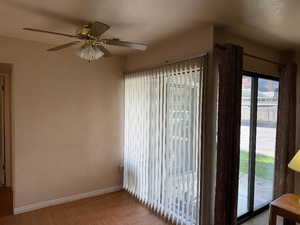 Spare room with baseboards, a textured wall, ceiling fan, and a textured ceiling