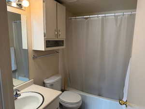 Bathroom featuring vanity, toilet, and shower / tub combo with curtain