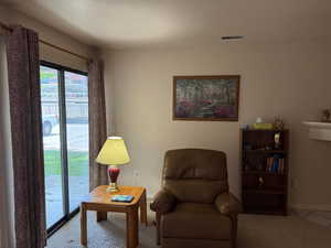 Living area featuring carpet flooring and baseboards