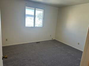 Bedroom featuring dark colored carpet and baseboards