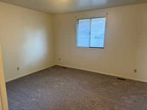 Bedroom with dark carpet and baseboards