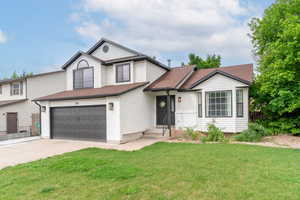 View of front of property with a garage, driveway, and roof with shingles