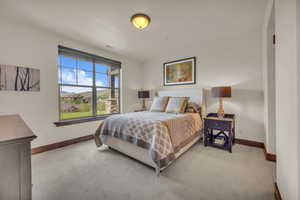 Bedroom with light carpet and baseboards