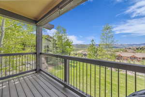 Wooden deck with a mountain view, a residential view, and a lawn