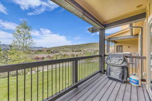 Wooden terrace with a mountain view and a lawn