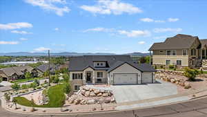 View of front facade with a mountain view, a garage, board and batten siding, and concrete driveway