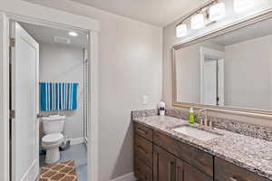Full bath with baseboards, toilet, and vanity