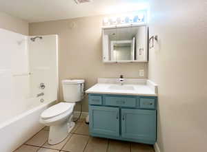 Full bathroom with toilet, vanity, tile patterned flooring, bathtub / shower combination, and baseboards