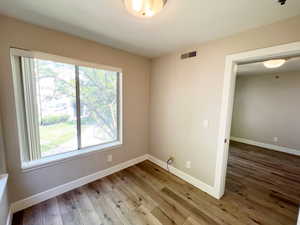 Empty room featuring wood finished floors and baseboards