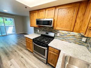 Kitchen featuring stainless steel appliances, light countertops, light wood finished floors, and a sink