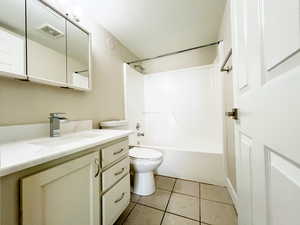 Full bath featuring vanity, toilet, tile patterned flooring, and bathtub / shower combination