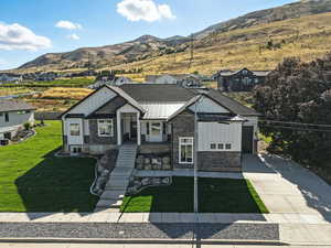 View of front of home with board and batten siding, a standing seam roof, stone siding, and a metal roof