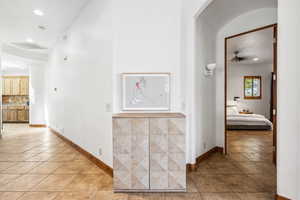 Hall with light tile patterned floors, recessed lighting, and baseboards