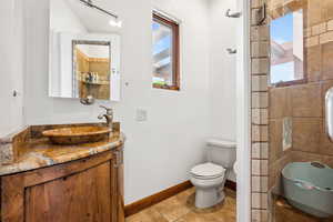 Bathroom featuring plenty of natural light, vanity, toilet, and tile patterned flooring