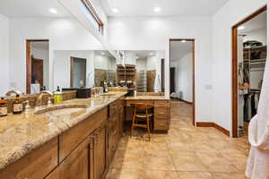 Bathroom with double vanity, tile patterned floors, a walk in closet, tasteful backsplash, and recessed lighting