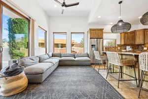 Living room with healthy amount of natural light, recessed lighting, dark tile patterned flooring, and a ceiling fan