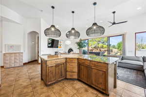 Kitchen featuring open floor plan, arched walkways, recessed lighting, light tile patterned floors, and ceiling fan