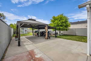 View of patio with a gazebo, outdoor dining space, and a grill