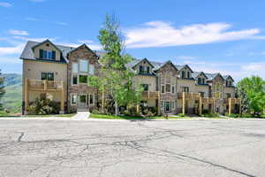 View of property featuring stone siding, a residential view, and a balcony