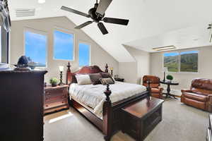 Bedroom featuring light carpet, lofted ceiling, a ceiling fan, and baseboards