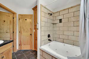 Full bathroom featuring a combined bath / shower with jetted tub and vanity