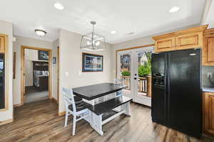 Dining room featuring french doors, wood finished floors, a chandelier, recessed lighting, and baseboards
